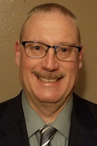 A man in a suit and tie photographed indoors.