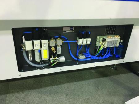 The pneumatic control panel of a machine, with filter regulator units, solenoid valves and a valve manifold wired into a terminal block.